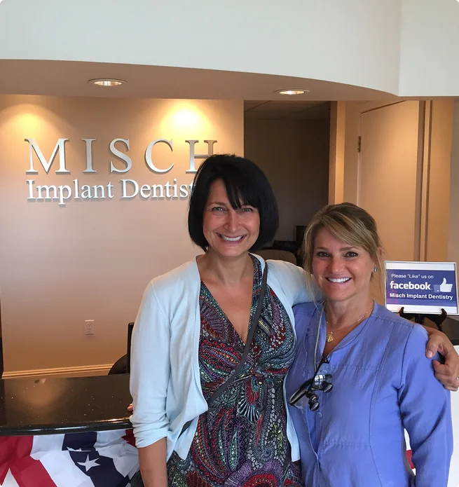 The interior reception area of Misch Implant Dentistry featuring the clinic logo and smiling team members.